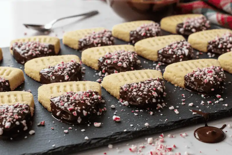 Shortbread triangles dipped in dark chocolate and garnished with crushed peppermint candy