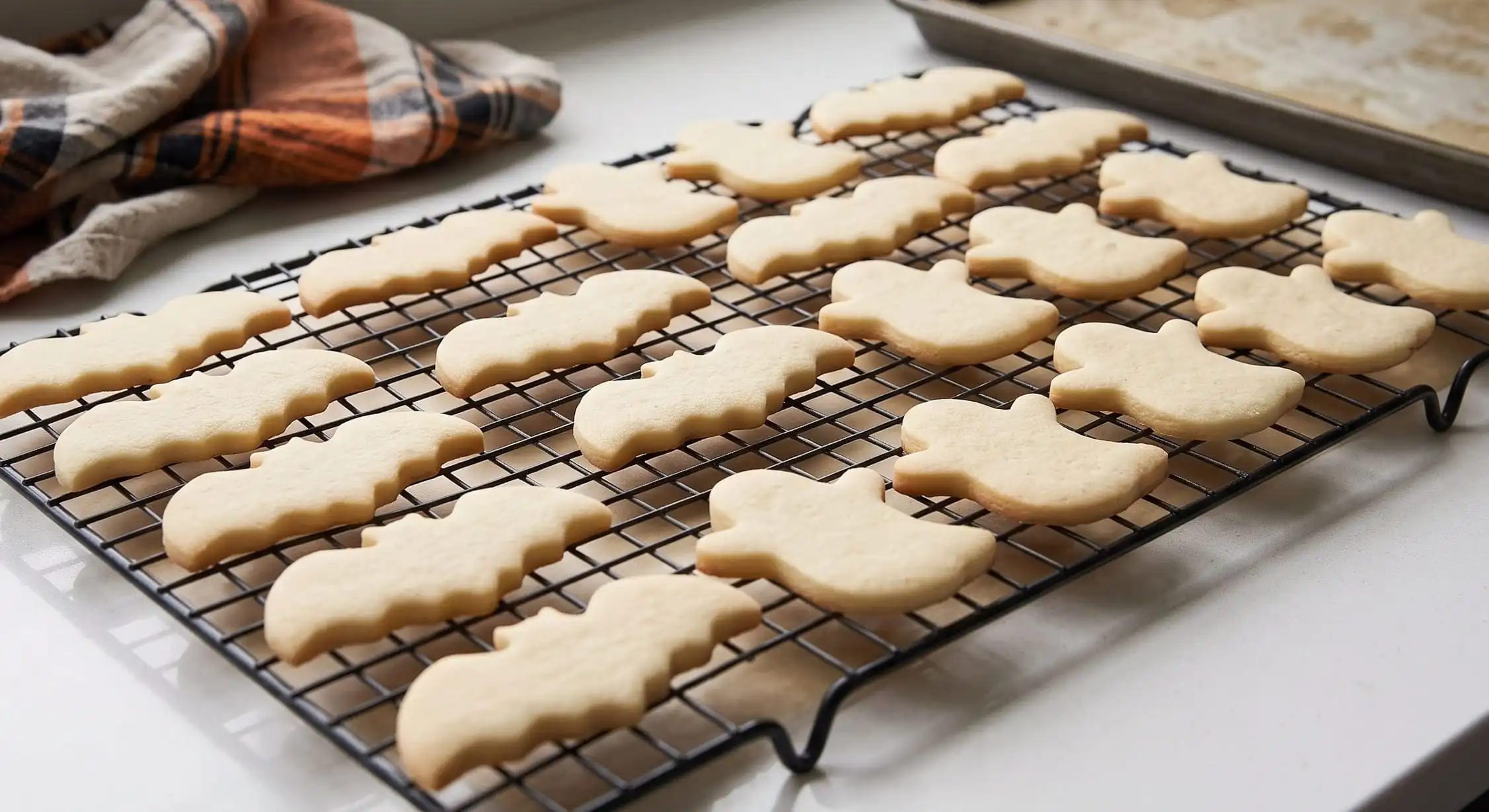 Frozen cookie cutouts arranged on a perforated silicone baking mat ready for the oven