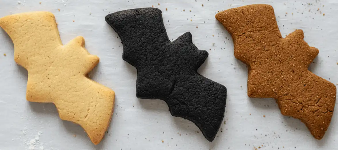 Side-by-side comparison of baked vanilla, black cocoa, and gingerbread Halloween cookies